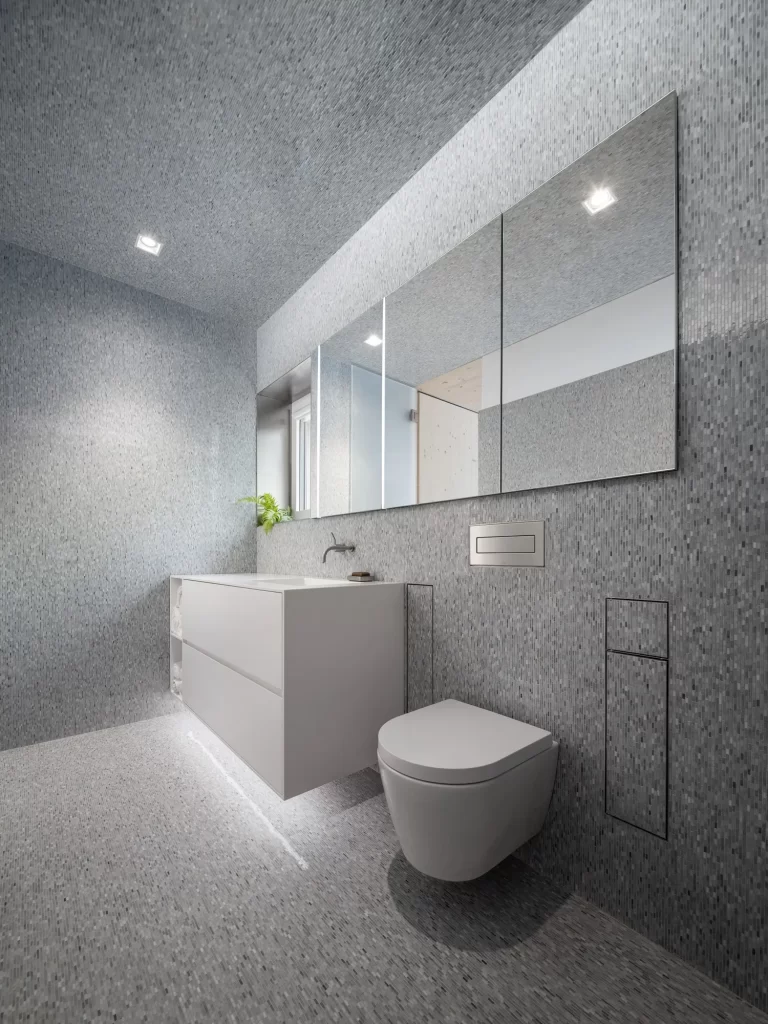 White vanity with large mirror in bathroom with grey tile on floor, ceiling and walls.