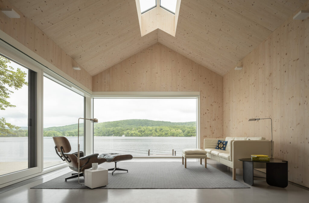 Cross-laminated timber (CLT) interior walls and ceiling with skylight and large triple paned glazing overlook lake view.